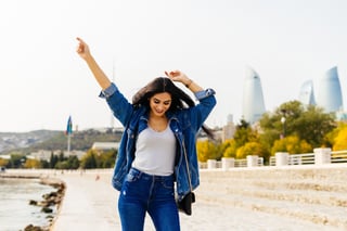 Femme heureuse en veste en jean marchant en ville