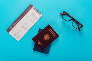 Contexte touristique avec billet d'avion ou carte d'embarquement, passeport français et lunettes